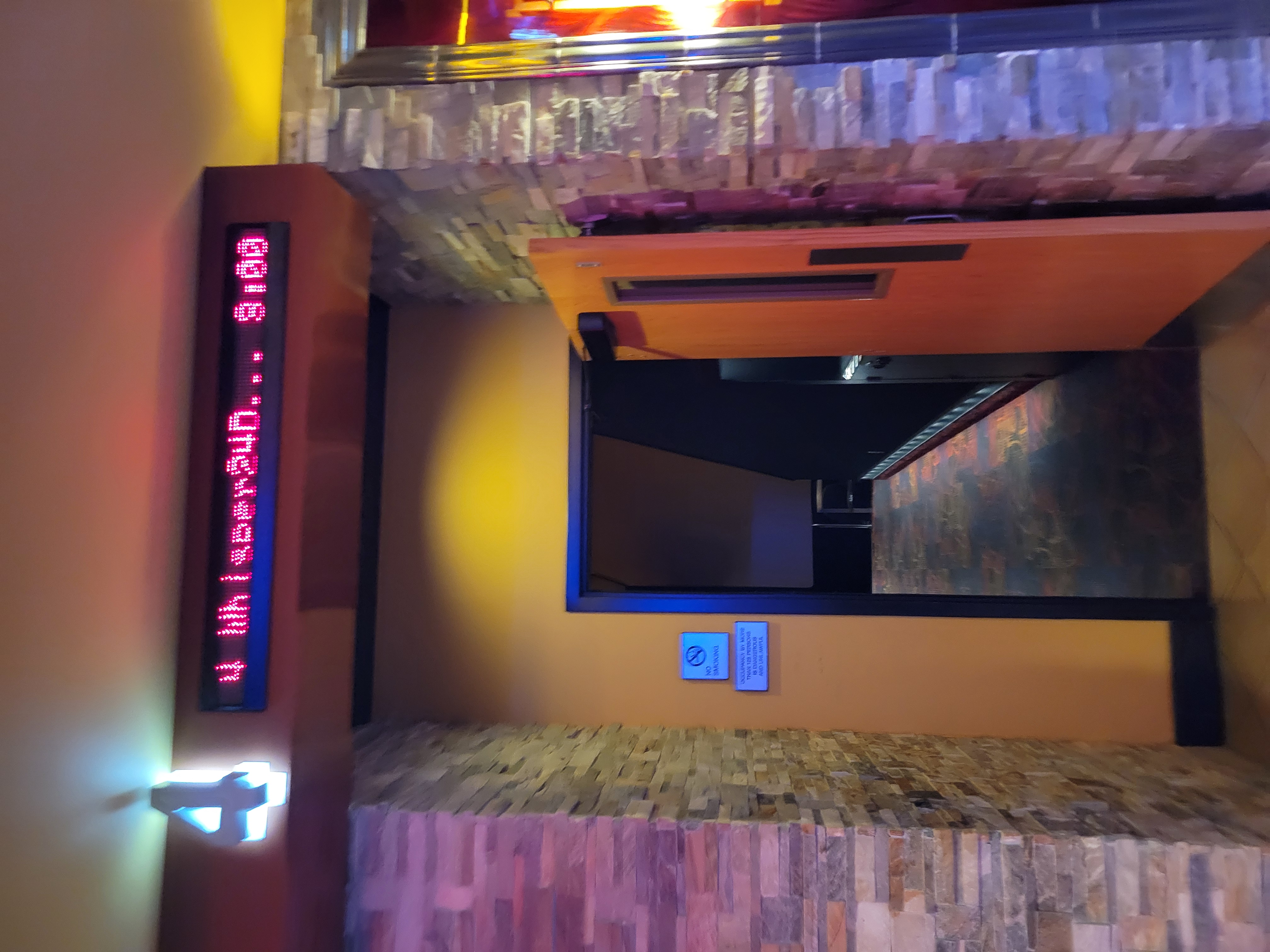 Entrance to a theater with the word 4 and Whisper24D...3:00 on a screen above.
